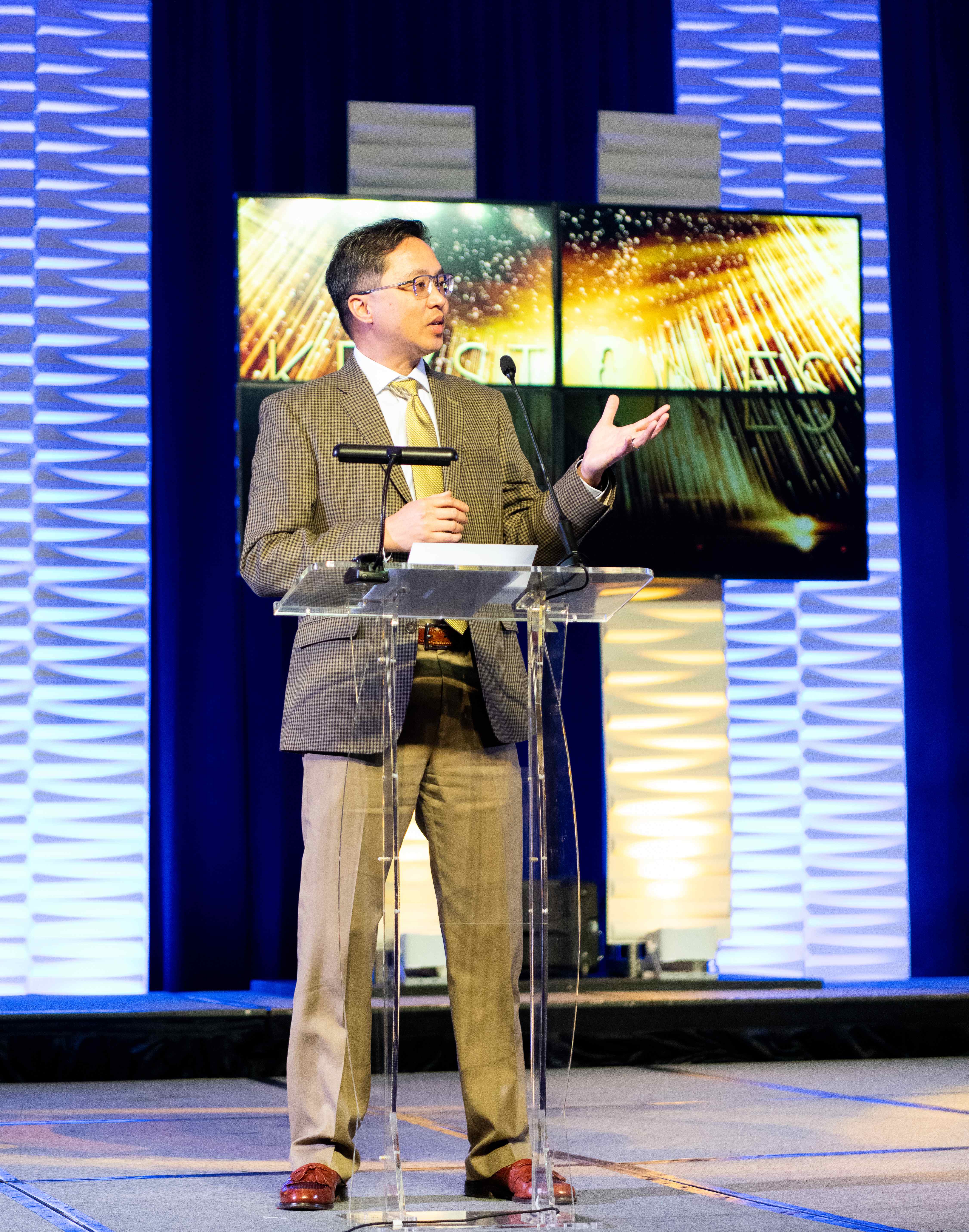 Jonathan Moral speaking from the podium at an industry conference